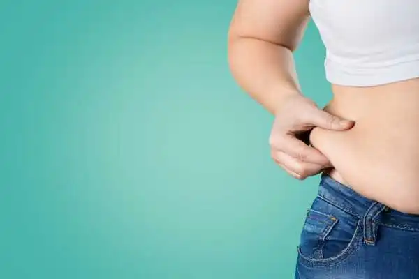 Image of woman pinching her love handles to show weight gain Bloxwich